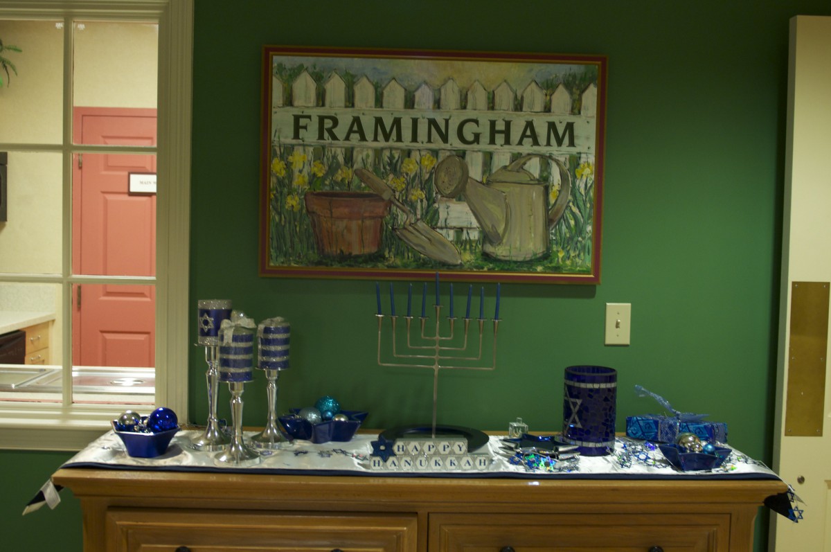 A display featuring a menorah and festive decorations beneath a 'Framingham' art piece on the wall.