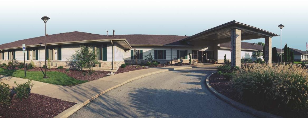 A one-story building with a sloped roof and a circular driveway.