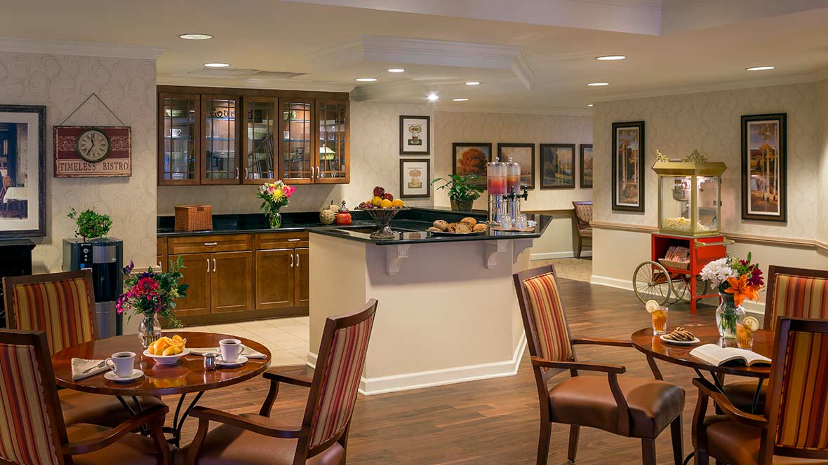 A cozy dining and kitchen area with warm lighting and wooden furnishings.