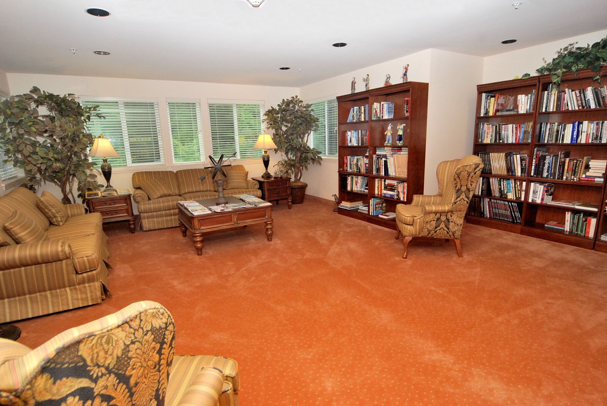 A cozy living room with bookshelves and comfortable seating.