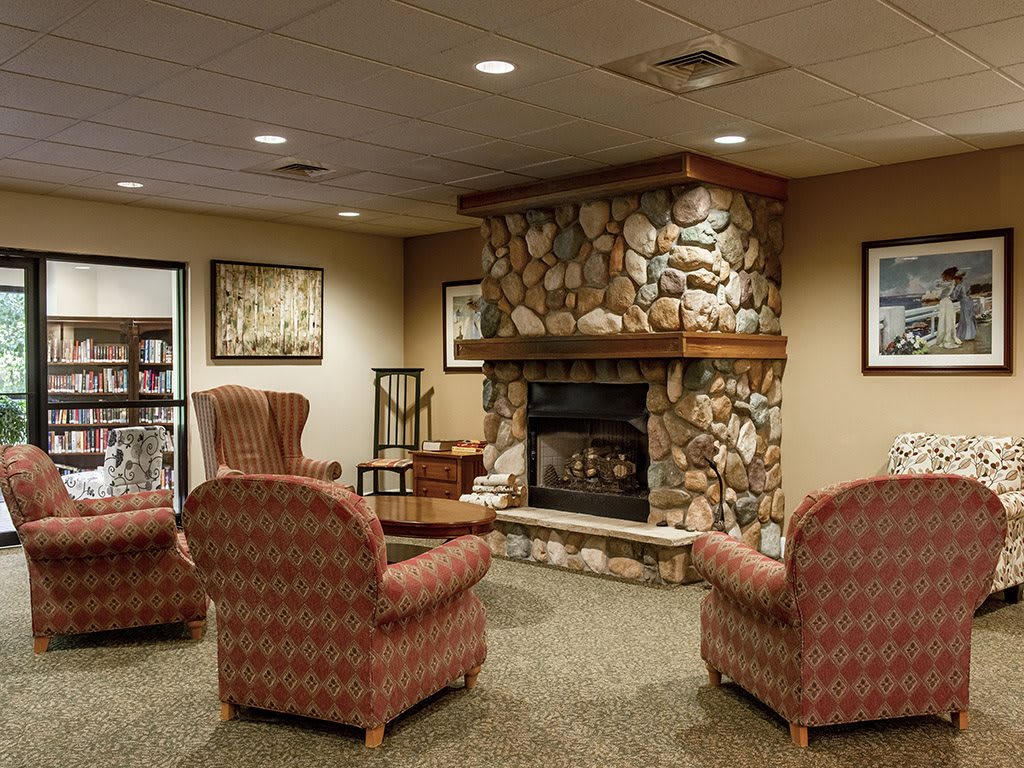 A cozy living room with a stone fireplace and comfortable seating.