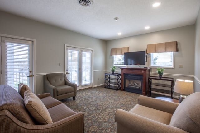A cozy living room with comfortable seating, a fireplace, and a television.