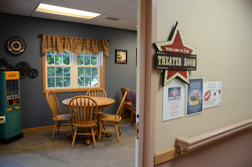 A cozy dining area with wooden furniture and a welcoming sign.