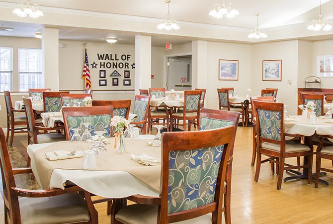 A well-decorated dining area featuring a 'Wall of Honor' with neatly arranged tables and chairs.