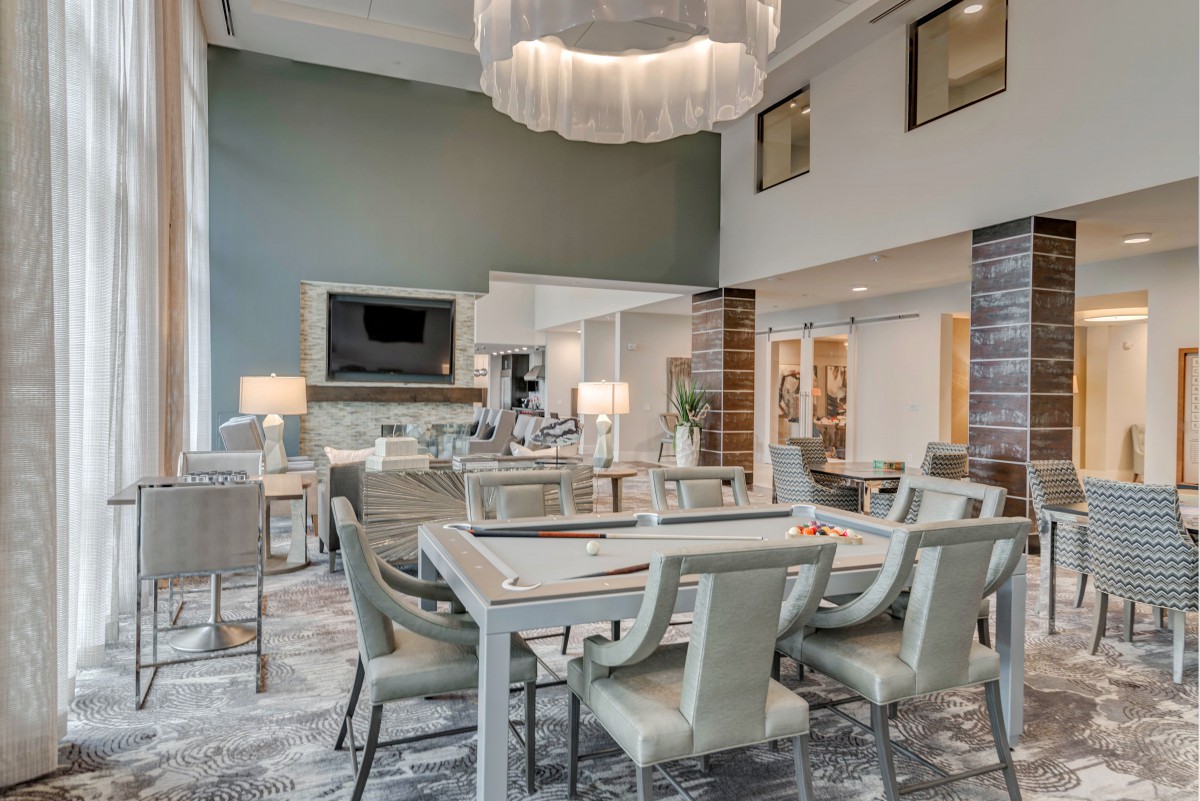 A modern and spacious dining area with contemporary furniture and a stylish chandelier.