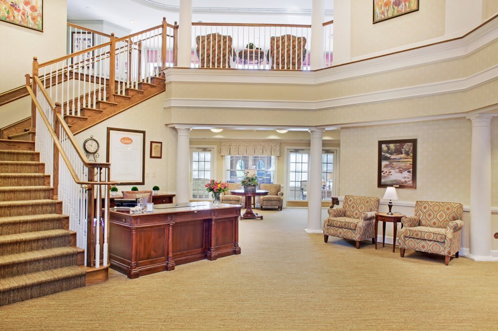 A welcoming lobby area with a large desk, comfortable seating, and elegant decor.