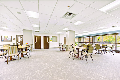 A spacious and inviting dining area featuring tables and chairs, designed for communal gatherings.