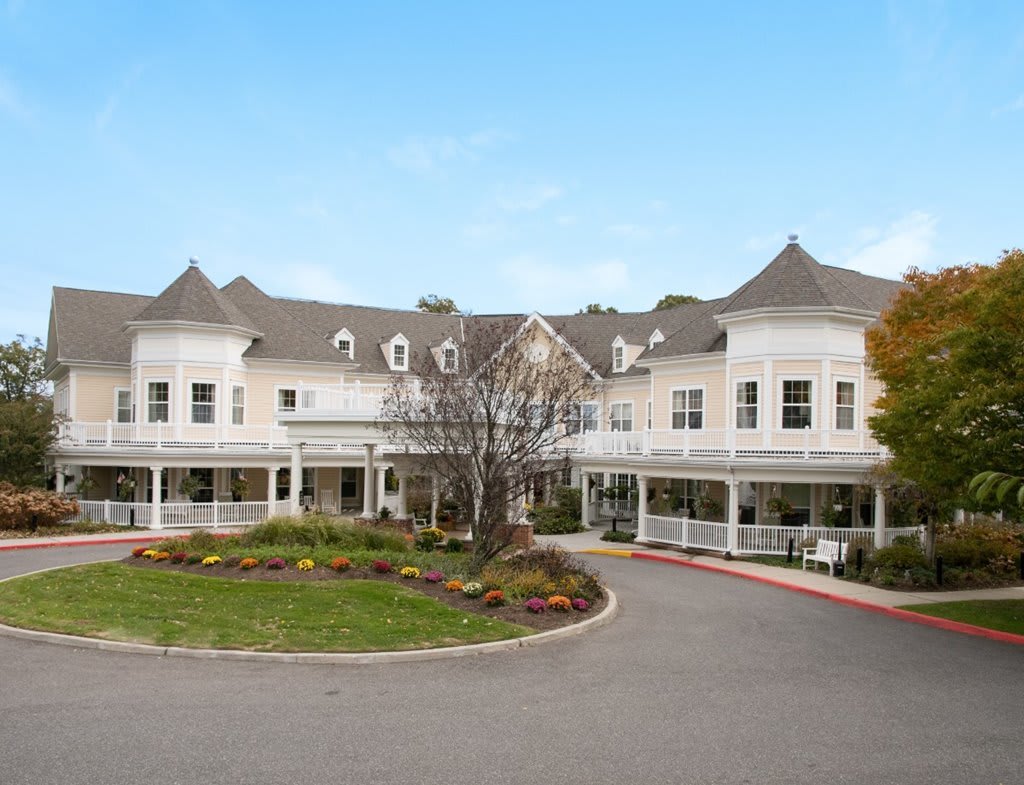 A large, elegant residential building with a circular driveway and well-maintained landscaping.