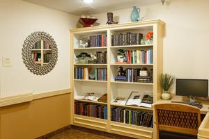 A cozy corner of a room featuring a well-organized bookshelf filled with books and decorative items.