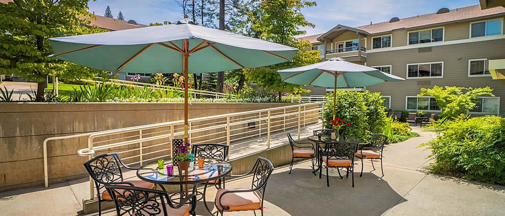 A sunny outdoor patio with tables and umbrellas, perfect for relaxation.