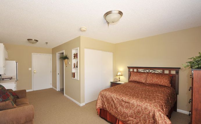 A cozy bedroom with a large bed, nightstand, and soft lighting.