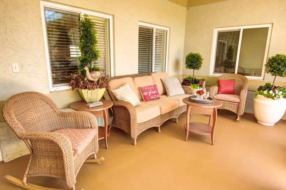 A cozy patio area with wicker furniture and colorful cushions.