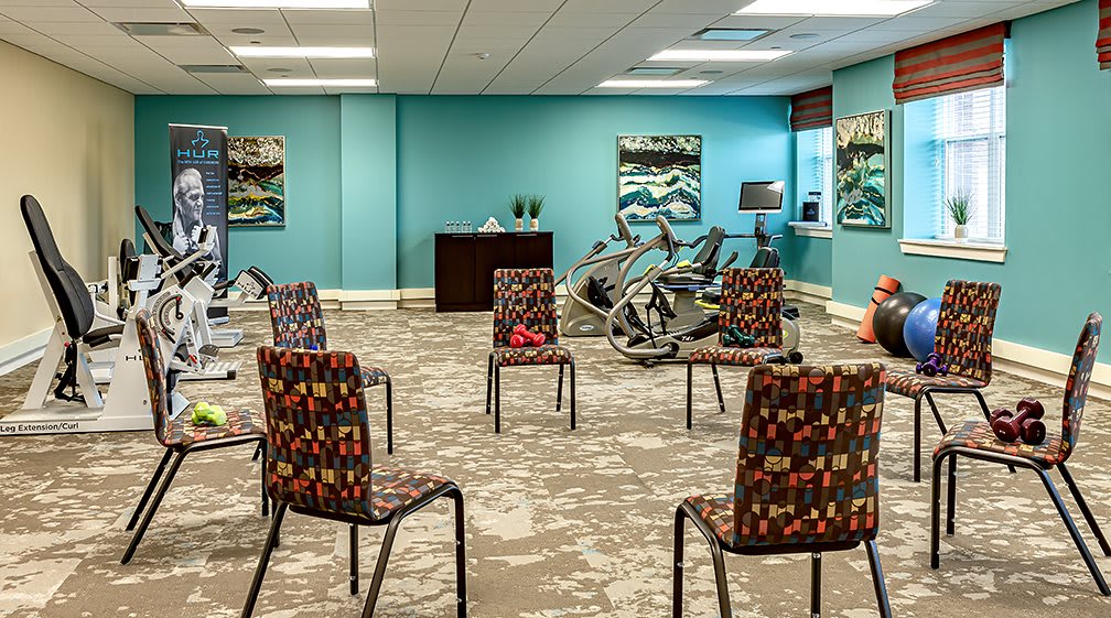 A meeting or training room with arranged chairs and exercise equipment.