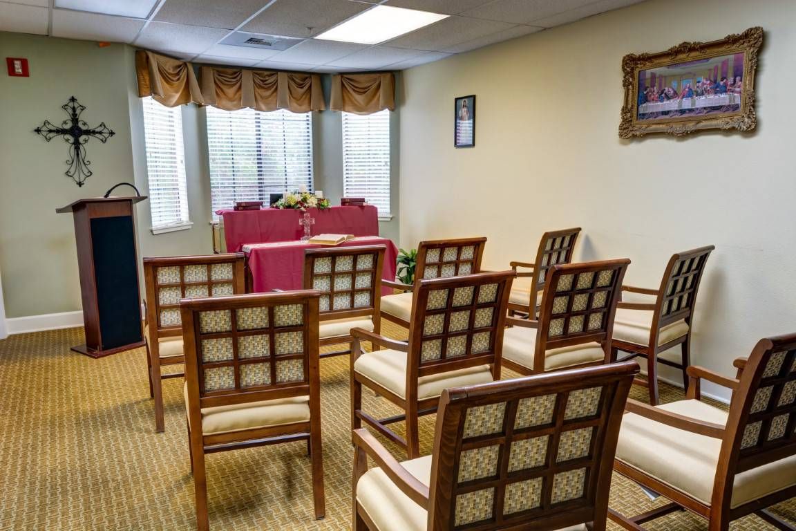 A small indoor ceremony room with arranged chairs and a central table.