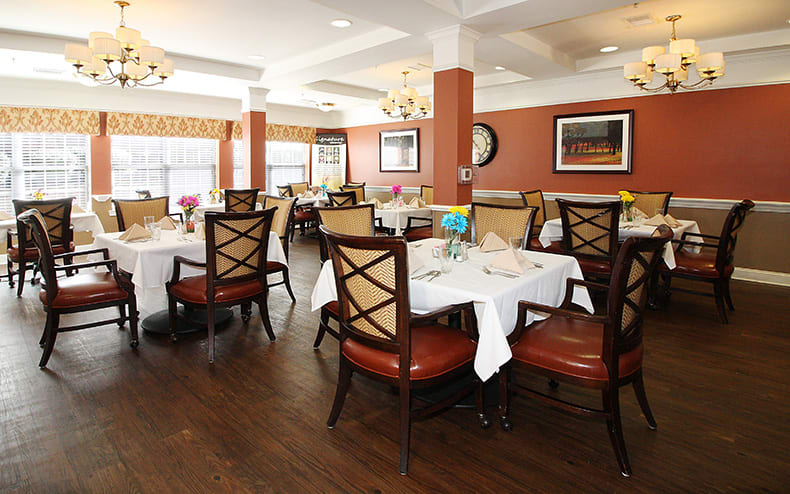 An elegant dining room with neatly arranged tables and chairs.