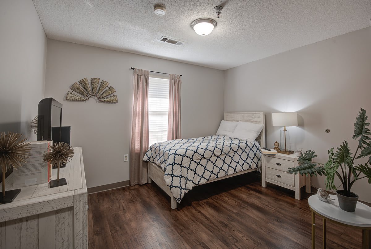 A cozy bedroom with a single bed, nightstand, and decorative elements.