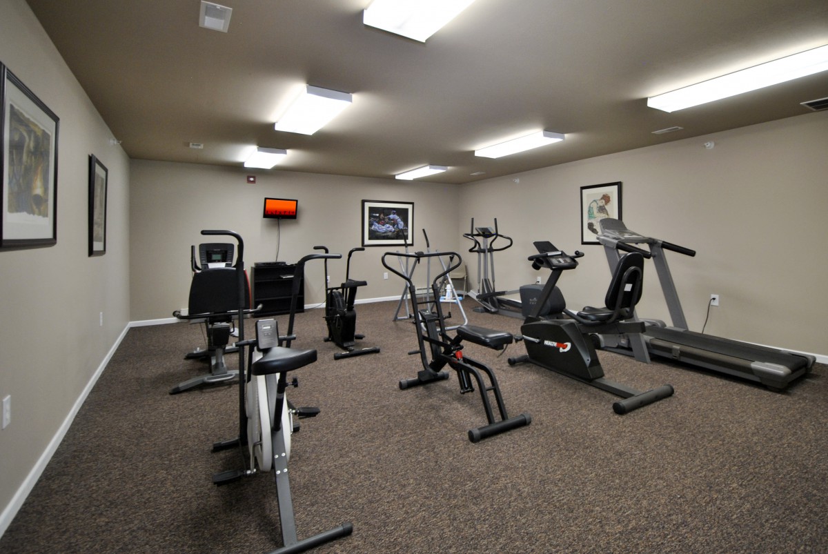 A well-equipped gym room with various exercise machines.
