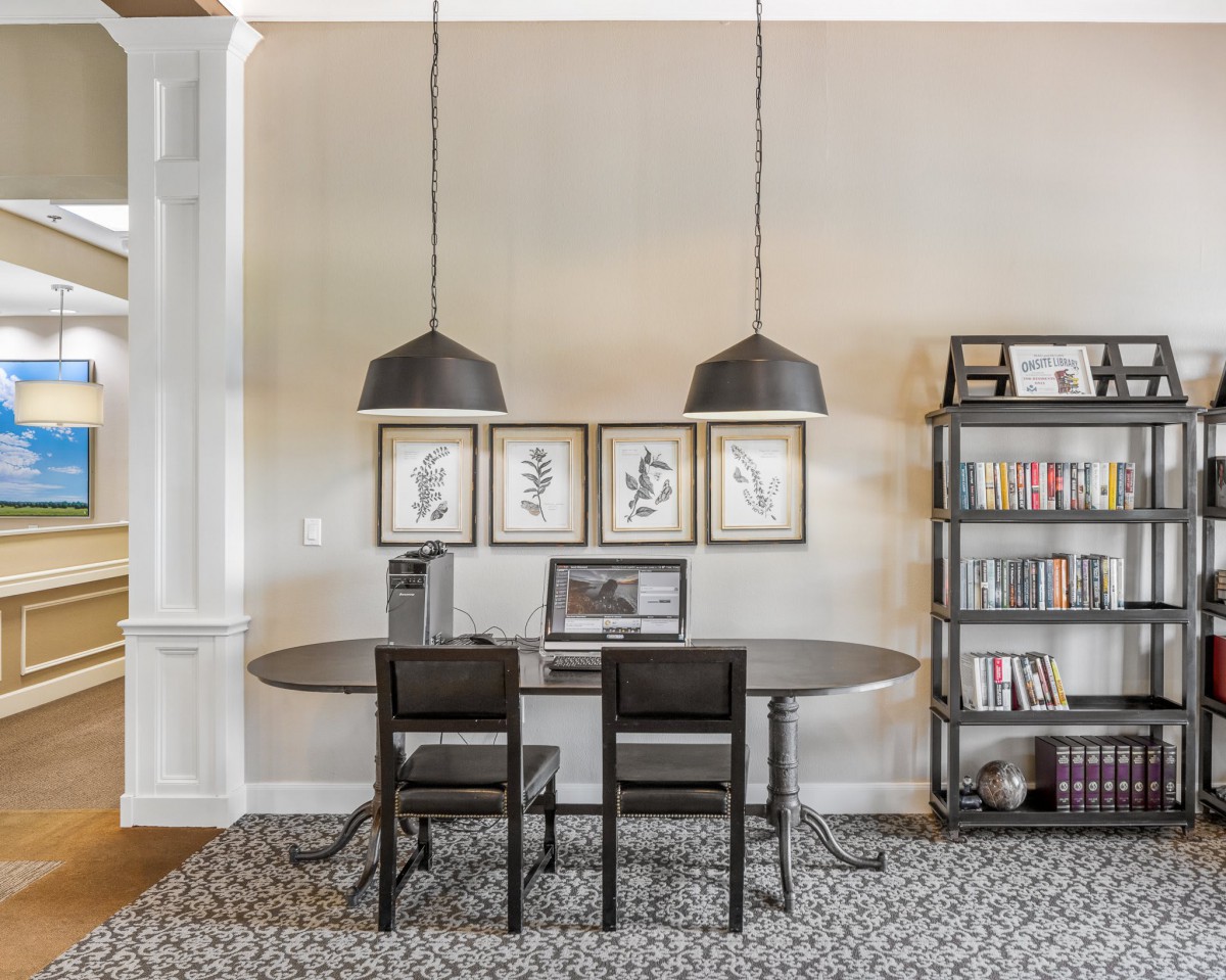 A modern home office setup with a sleek desk, pendant lighting, and minimalist decor.