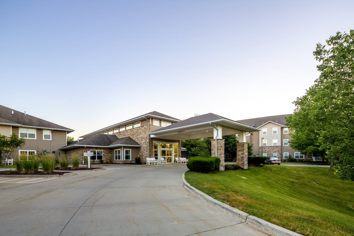 A modern building with a driveway and landscaped surroundings.