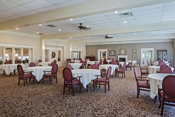 An elegant dining room setup with multiple tables and chairs on a carpeted floor.