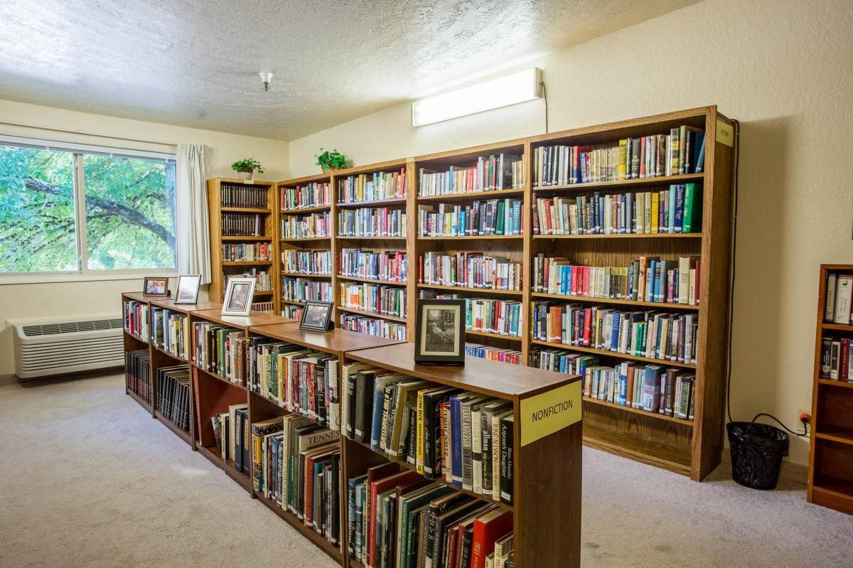 A cozy library corner with rows of bookshelves filled with a variety of books.