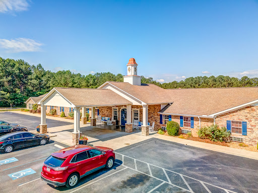 A welcoming community center featuring a well-maintained exterior and ample parking on a sunny day.