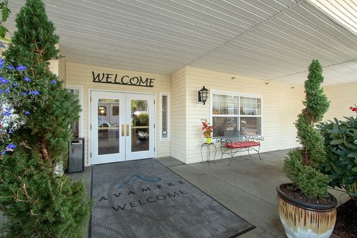 The entrance of a building with a welcome sign above the doors.