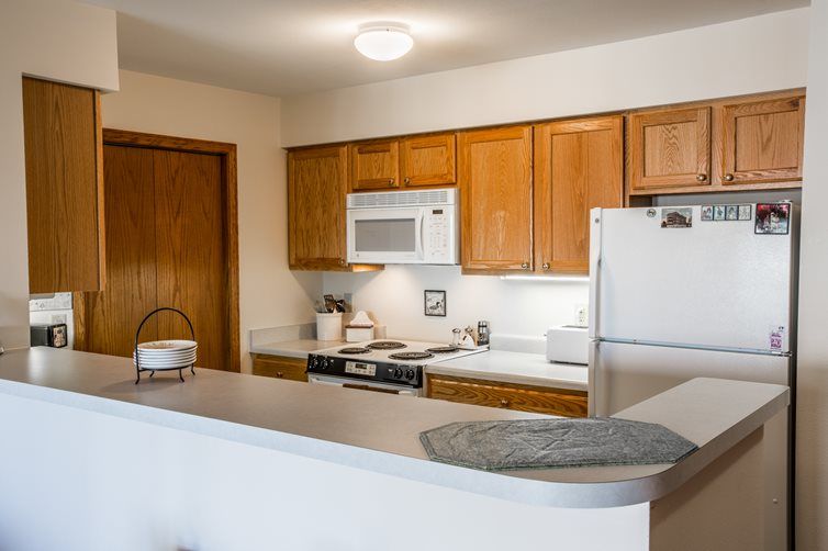 A modern kitchen with wooden cabinets and essential appliances.