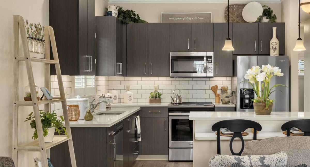 Modern kitchen with dark cabinets and stainless steel appliances.