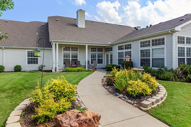 A beautiful backyard with well-maintained landscaping and a pathway leading to the house.