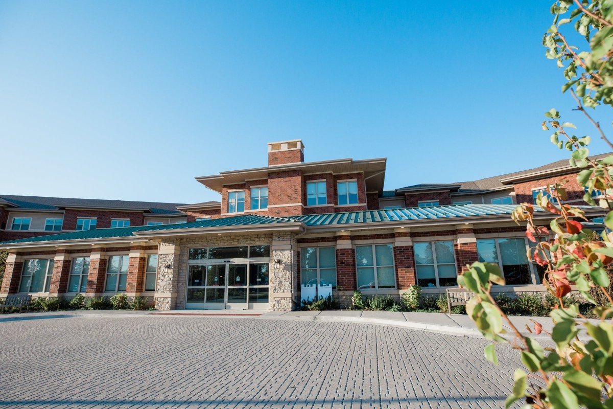 A modern commercial building with a brick exterior and large windows under a clear blue sky.