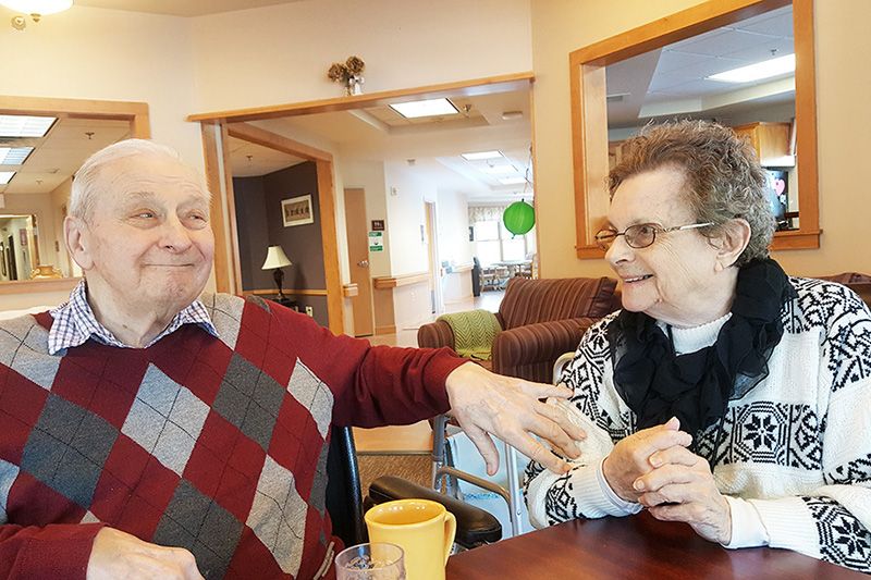An elderly couple sharing a joyful moment together indoors.