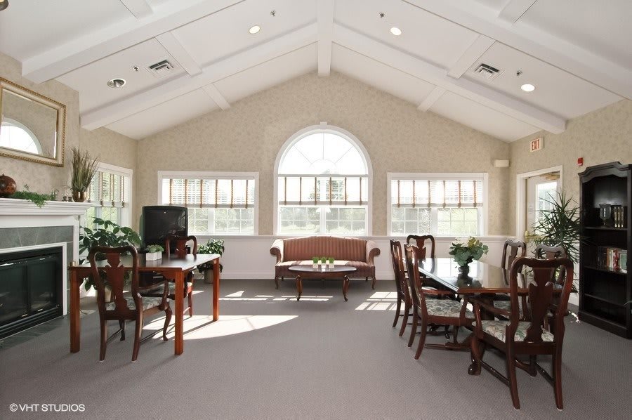 A spacious living room with elegant wooden furniture and large windows.