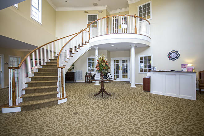 A spacious lobby with a curved staircase and elegant interior design.