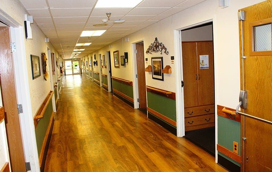 A well-lit hallway with wooden floors and artwork adorning the walls.