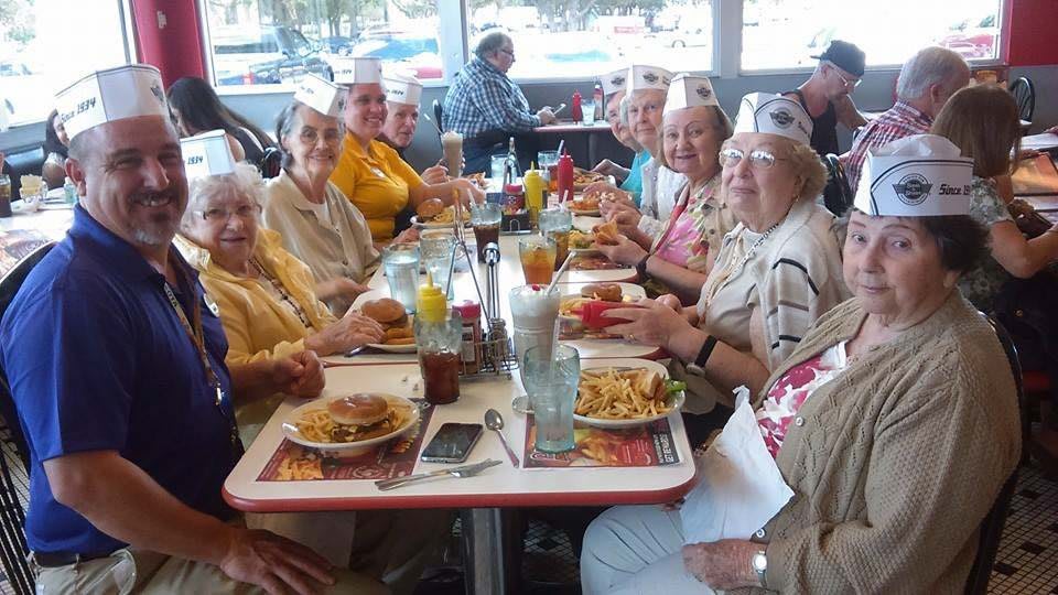 A group of seniors enjoying a meal together at a retro-style diner.
