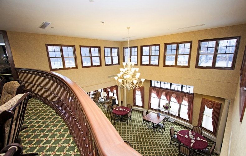 A spacious dining area with a chandelier, viewed from an upper-level balcony.