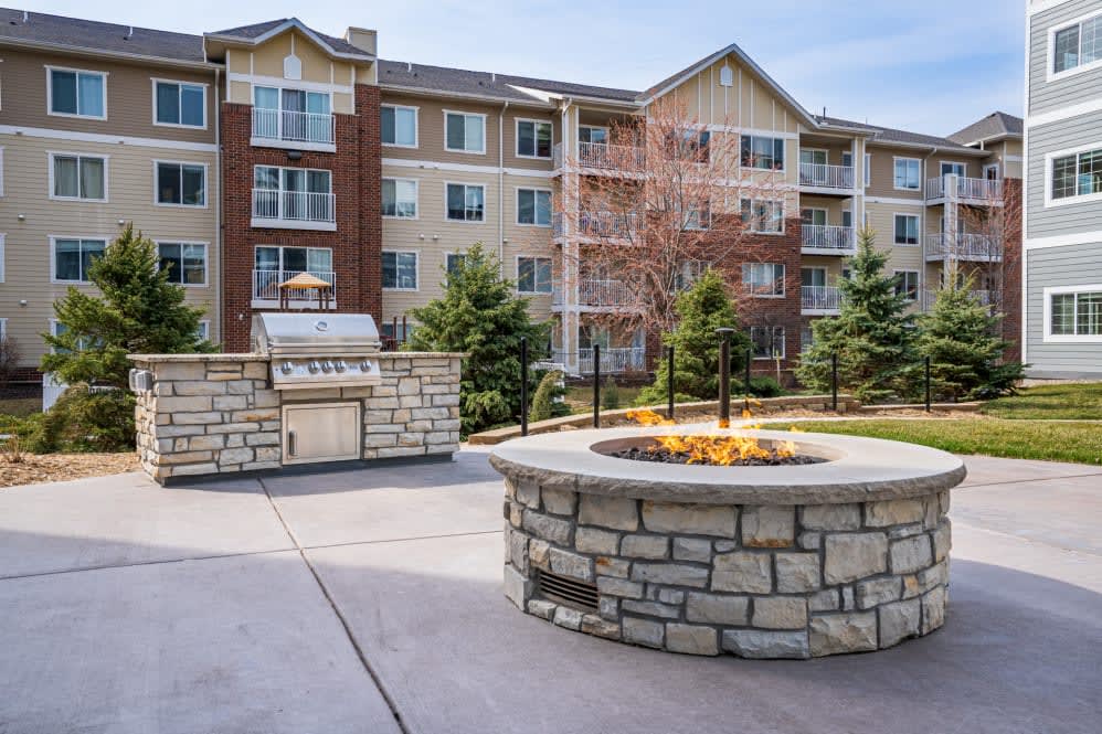 Outdoor view of a residential apartment complex with a fire pit and landscaped surroundings.