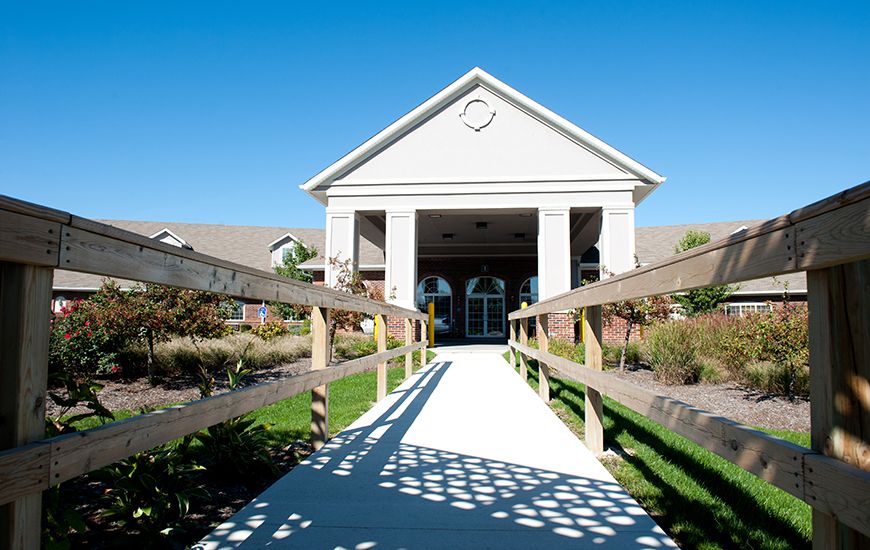 A pathway leading to the entrance of a modern building on a sunny day.