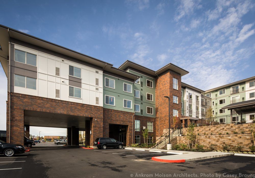Modern residential apartment building exterior under a clear sky.