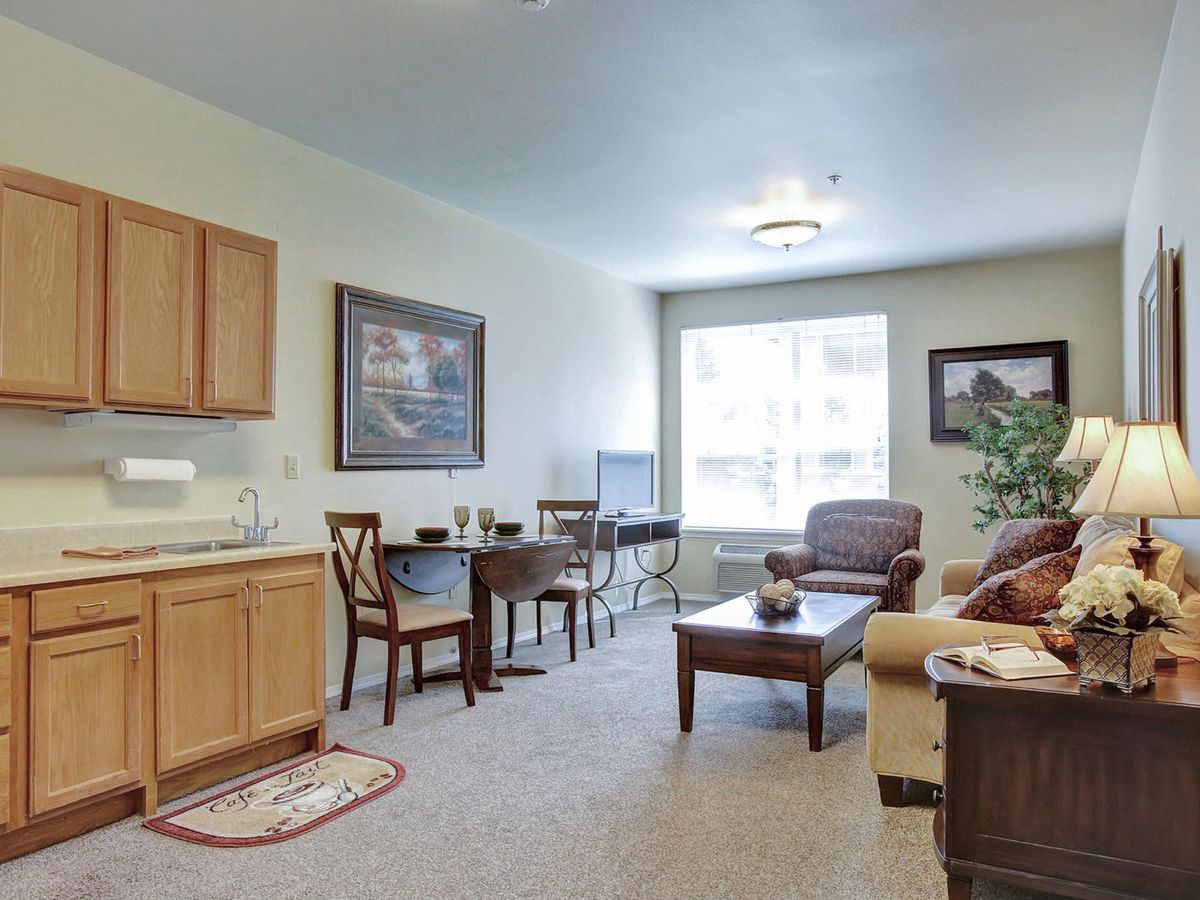 A cozy living room with a kitchenette, featuring comfortable seating and tasteful decor.