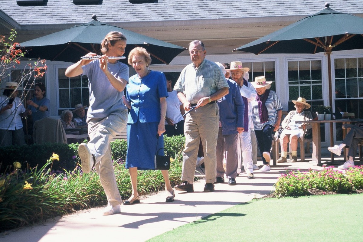 A group of seniors enjoying a lively dance session outdoors.