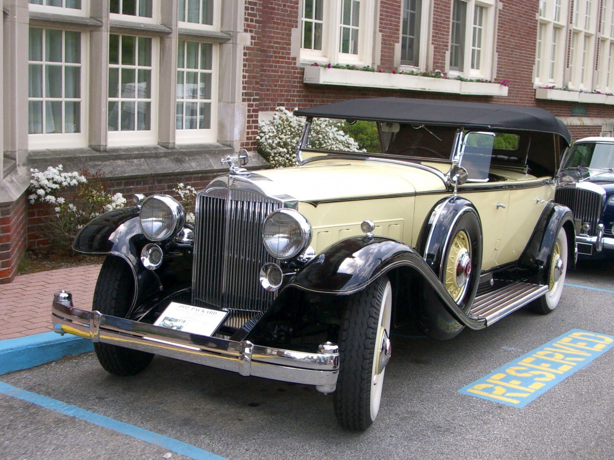 A beautifully restored vintage convertible parked outside a building.