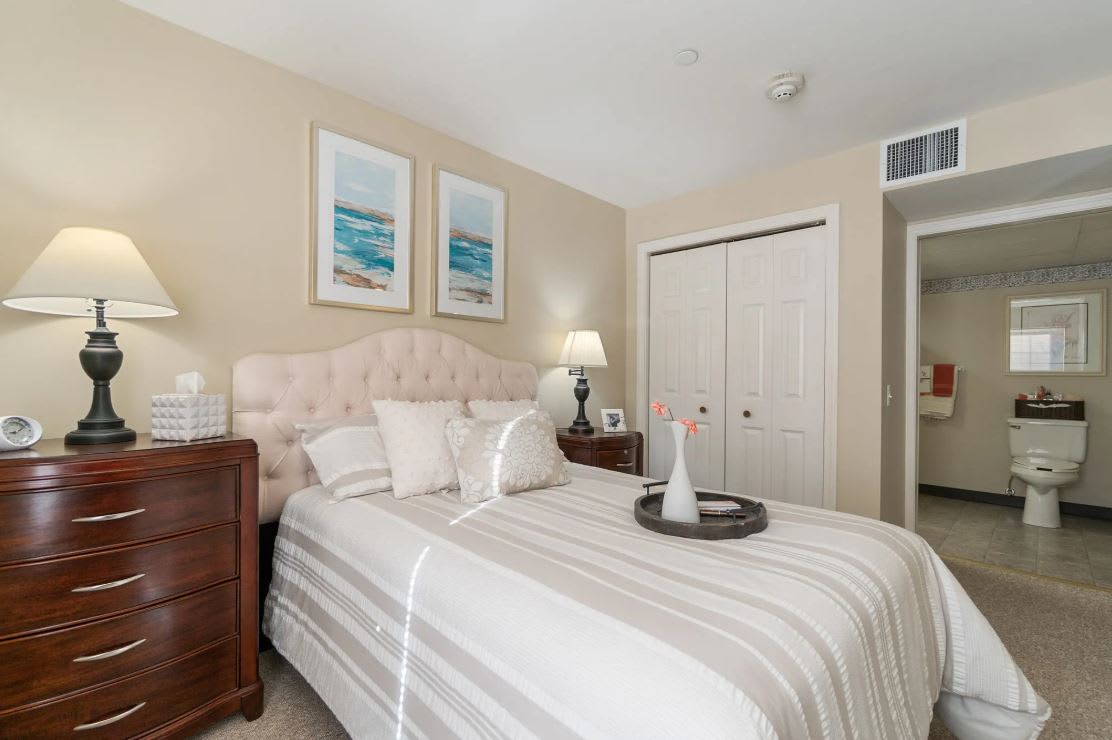 A cozy and elegantly designed bedroom with a neatly made bed, stylish decor, and soft lighting.