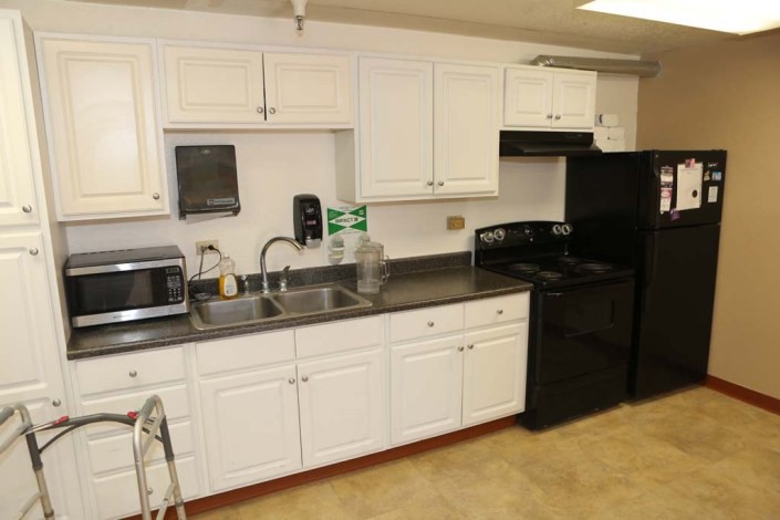 A modern kitchen with white cabinets, equipped with appliances including a microwave, oven, and refrigerator.