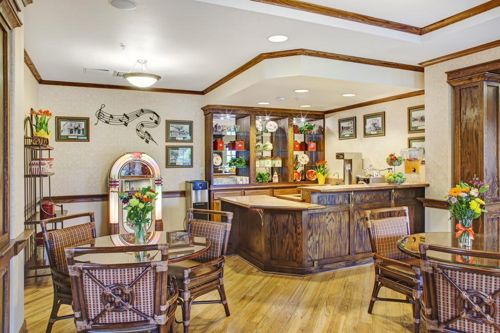 A cozy, retro-themed cafe interior featuring a jukebox and wooden furniture.