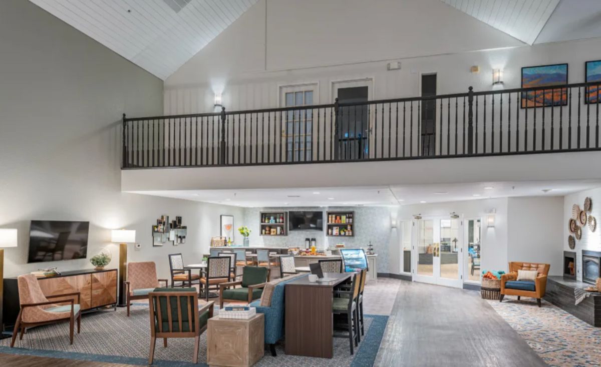 A modern hotel lobby with a spacious seating area and high ceilings.