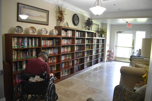 A cozy library space featuring well-stocked shelves and a wheelchair user enjoying a moment of reading.