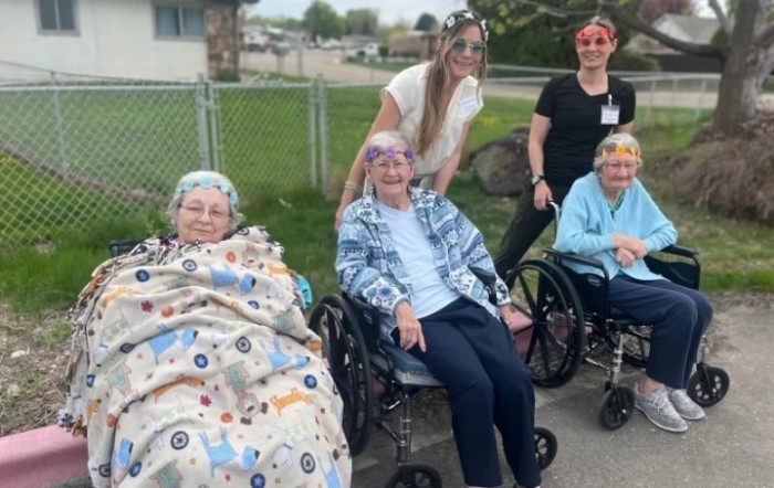 A cheerful group of elderly people and caregivers enjoying time outdoors.