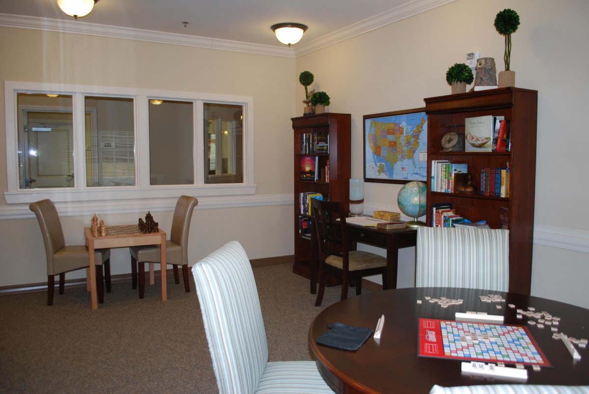 A well-organized office space with a desk, bookshelves, and a table with chairs.